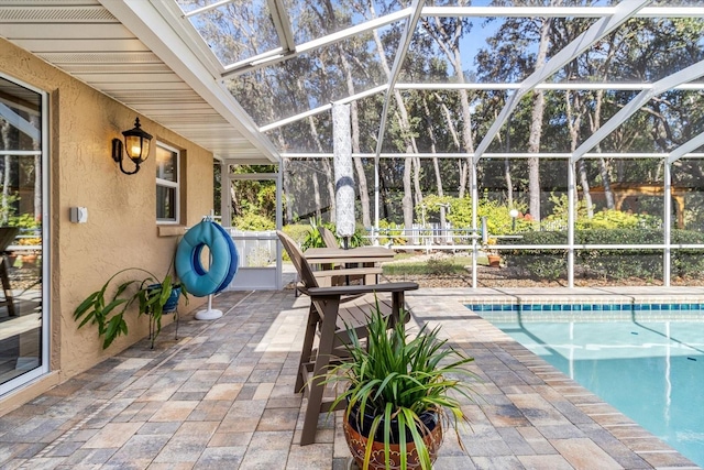 view of pool featuring glass enclosure and a patio