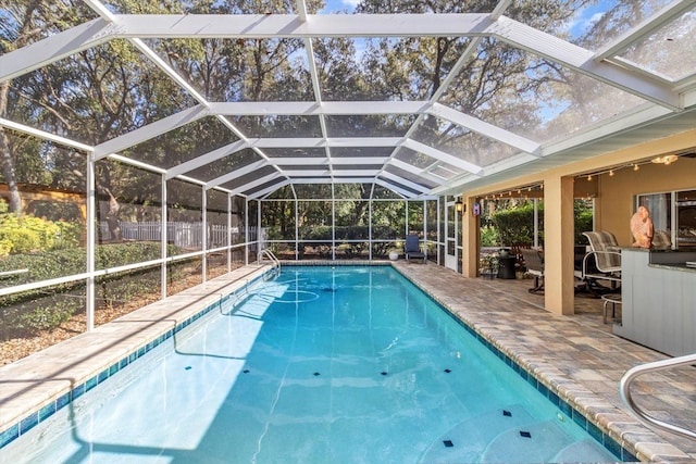 view of swimming pool with a patio and glass enclosure