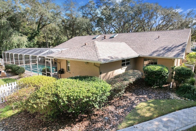 rear view of property featuring glass enclosure