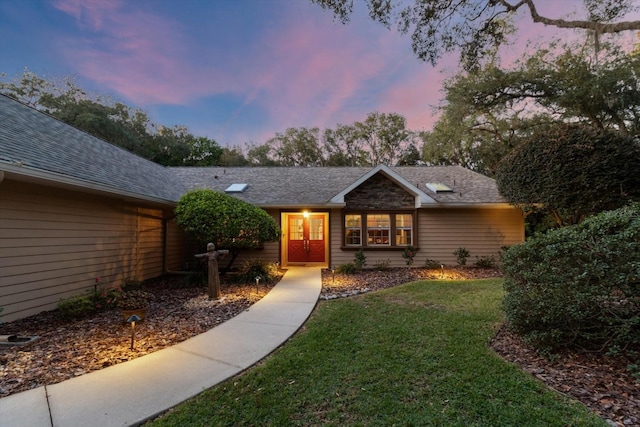 ranch-style home featuring a lawn