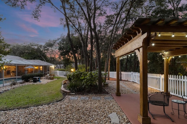 yard at dusk featuring a patio area, a lanai, and a fenced in pool