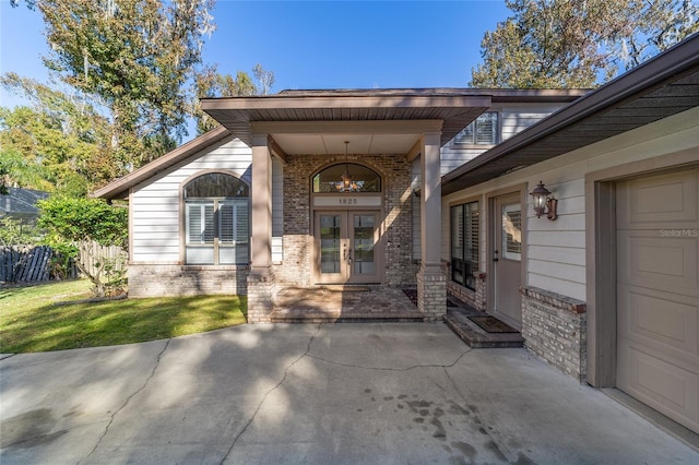 property entrance featuring a garage and french doors