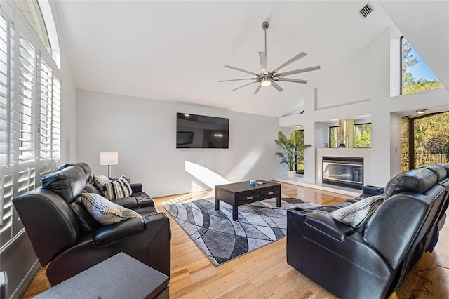 living room featuring wood-type flooring, high vaulted ceiling, and ceiling fan