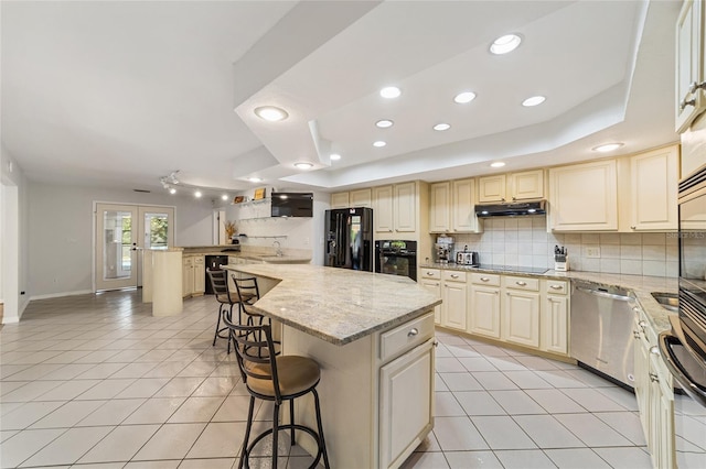 kitchen featuring french doors, black appliances, light stone counters, a kitchen island, and a kitchen bar