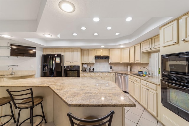 kitchen with black appliances, a kitchen breakfast bar, sink, light stone countertops, and light tile patterned floors