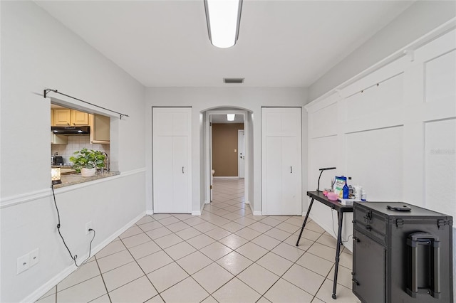 kitchen with decorative backsplash, light brown cabinets, and light tile patterned floors