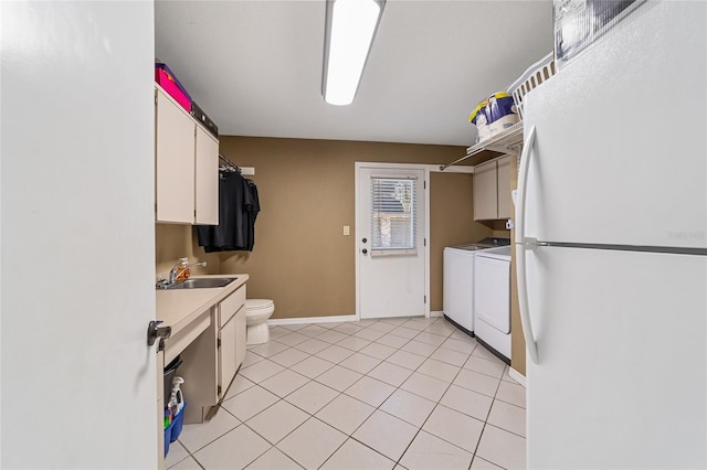 kitchen featuring light tile patterned flooring, sink, washing machine and dryer, white fridge, and white cabinetry