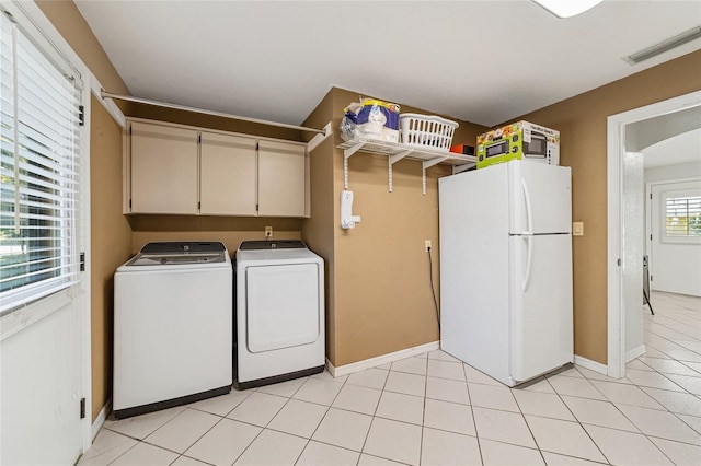 washroom featuring cabinets, light tile patterned floors, and washer and clothes dryer