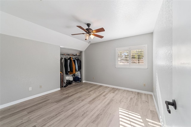 unfurnished bedroom with light wood-type flooring, a closet, vaulted ceiling, and ceiling fan