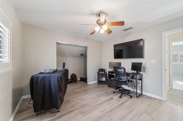 office with light hardwood / wood-style flooring and ceiling fan