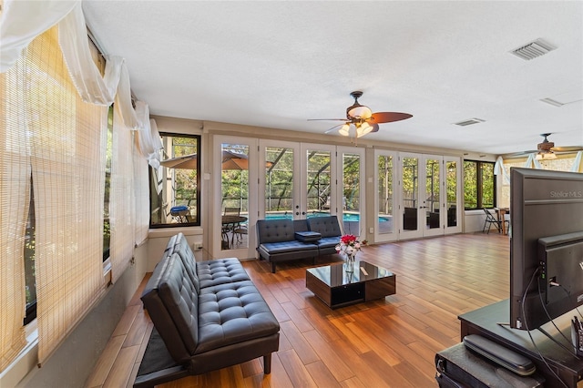 interior space with ceiling fan, a wealth of natural light, and french doors