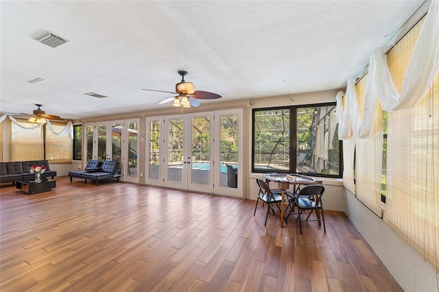 sunroom featuring ceiling fan and french doors