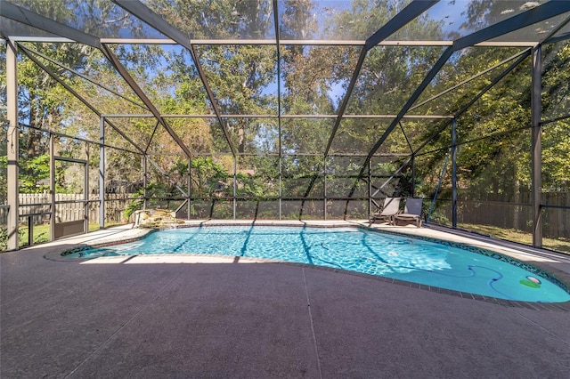 view of pool with glass enclosure and a patio