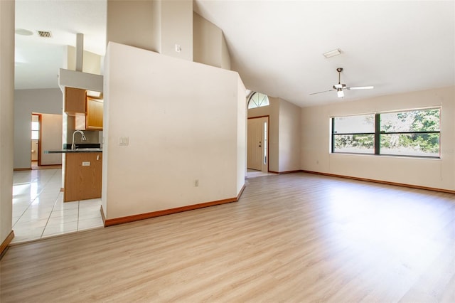 interior space with ceiling fan, light hardwood / wood-style flooring, high vaulted ceiling, and sink