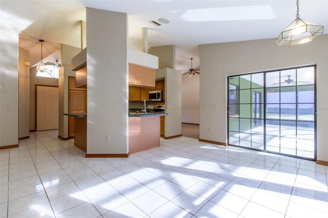 kitchen with light tile patterned flooring, hanging light fixtures, and high vaulted ceiling