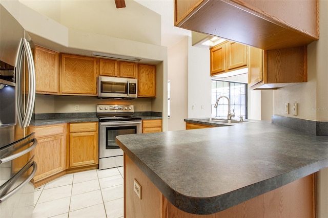 kitchen with kitchen peninsula, sink, light tile patterned floors, and stainless steel appliances