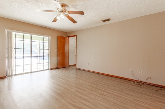 spare room with ceiling fan, a textured ceiling, and light wood-type flooring