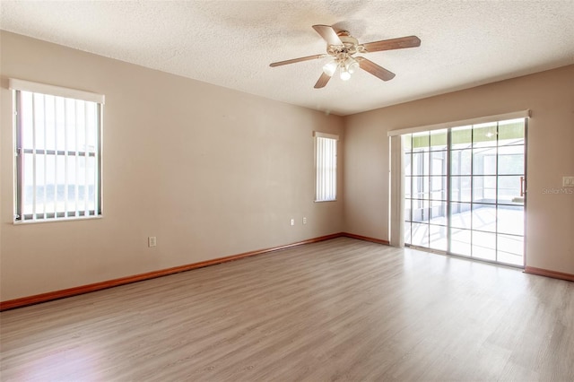 unfurnished room featuring a textured ceiling, light wood-type flooring, and ceiling fan