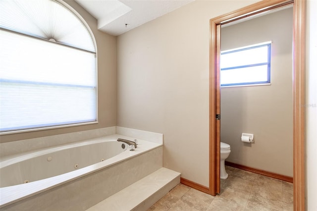 bathroom featuring tile patterned flooring, a washtub, and toilet