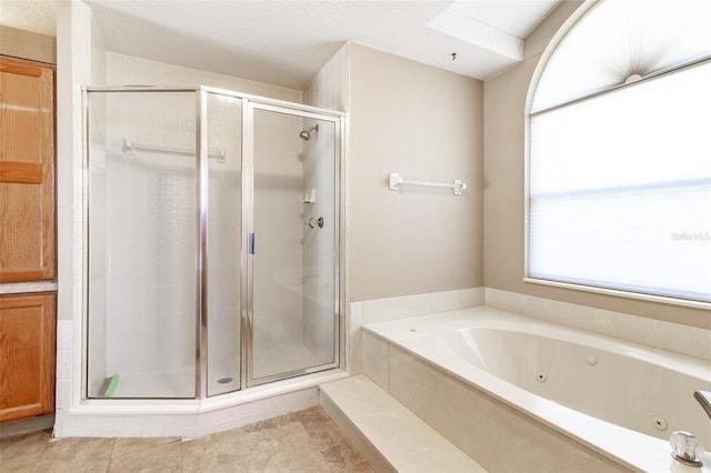 bathroom with plus walk in shower, a textured ceiling, and tile patterned floors