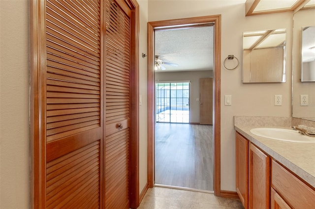 bathroom featuring ceiling fan, hardwood / wood-style floors, vanity, and a textured ceiling