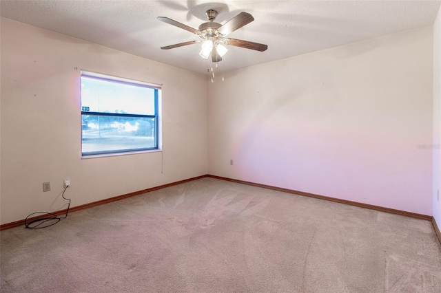 carpeted spare room featuring ceiling fan and a textured ceiling