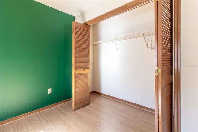 unfurnished bedroom with light wood-type flooring and a closet