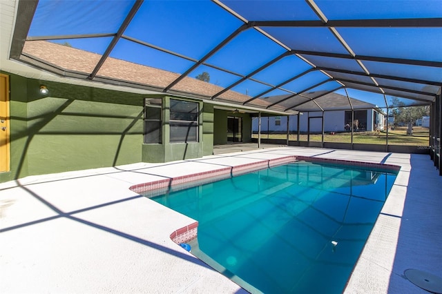 view of pool featuring glass enclosure and a patio