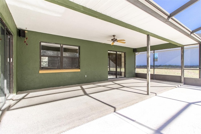 unfurnished sunroom with beam ceiling and ceiling fan