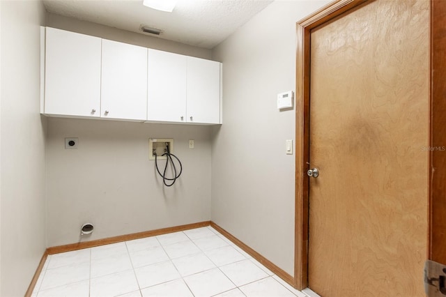 laundry room featuring electric dryer hookup, hookup for a washing machine, cabinets, and a textured ceiling