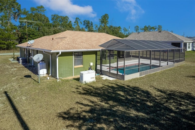 back of house with a lanai, a patio area, a lawn, and cooling unit