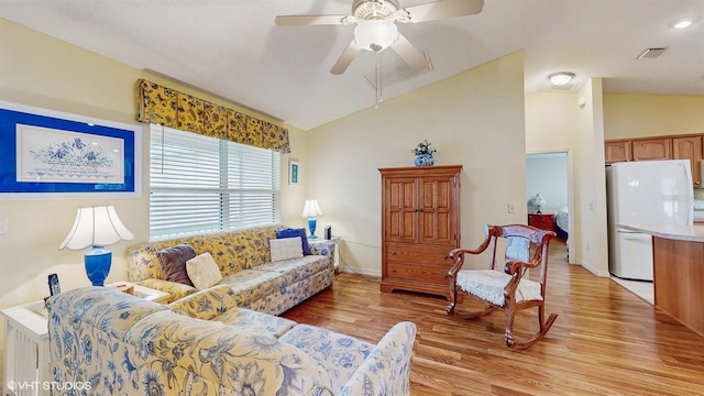 living room with lofted ceiling, ceiling fan, light wood-type flooring, and visible vents