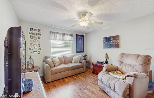 living room with a textured ceiling, light hardwood / wood-style floors, and ceiling fan