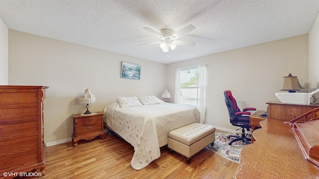 bedroom featuring ceiling fan, a textured ceiling, and light hardwood / wood-style flooring