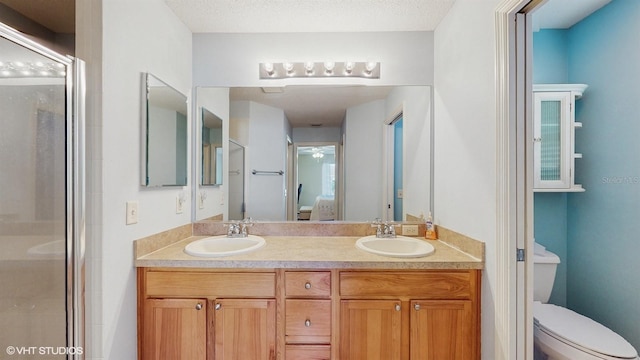 bathroom with ceiling fan, walk in shower, a textured ceiling, toilet, and vanity