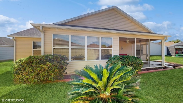 back of house with a sunroom and a yard