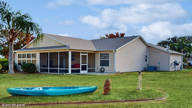 rear view of property with a sunroom, cooling unit, and a lawn