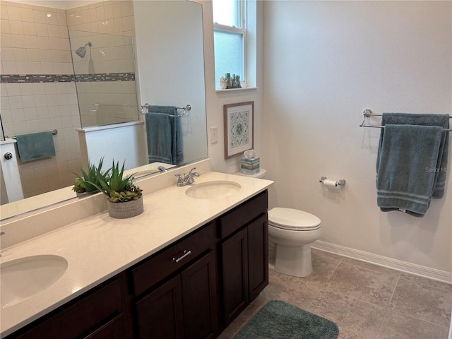 bathroom with toilet, vanity, and tiled shower