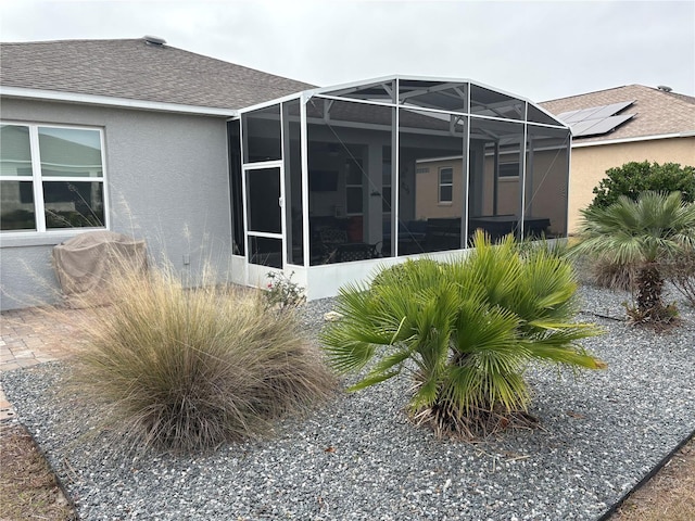 rear view of house featuring glass enclosure