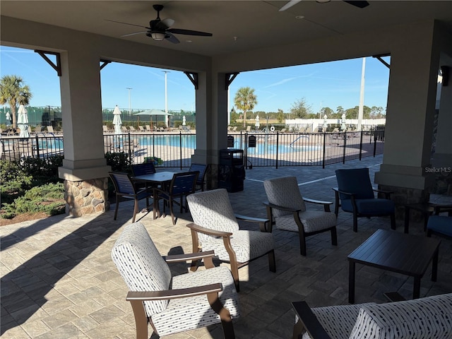 view of patio with ceiling fan and a community pool