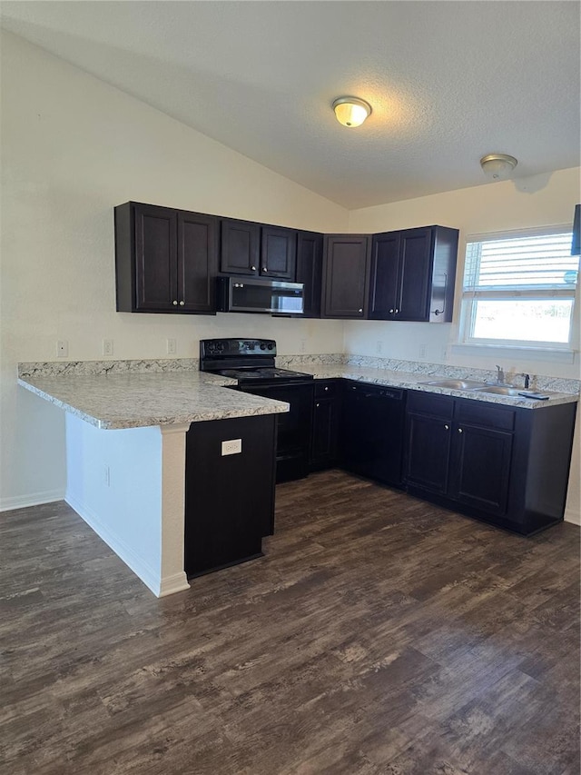 kitchen featuring kitchen peninsula, black appliances, dark wood-type flooring, and lofted ceiling