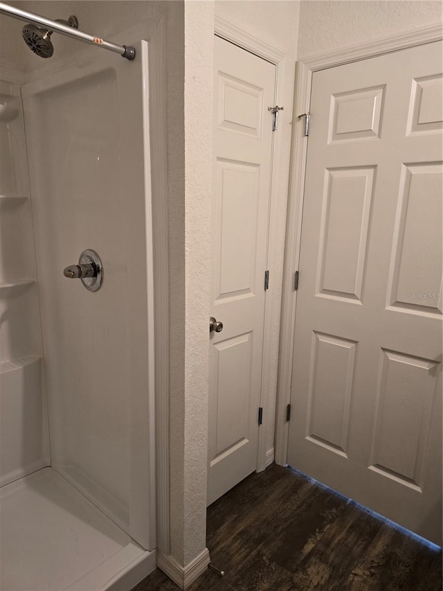 bathroom featuring hardwood / wood-style flooring and walk in shower