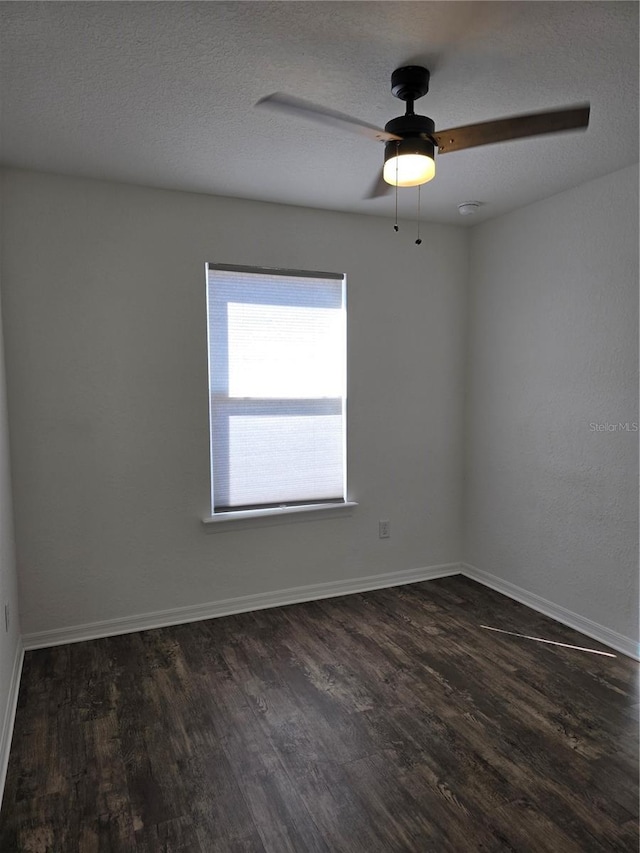 spare room with ceiling fan, dark wood-type flooring, and a textured ceiling