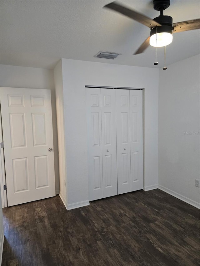 unfurnished bedroom with a closet, ceiling fan, and dark hardwood / wood-style flooring