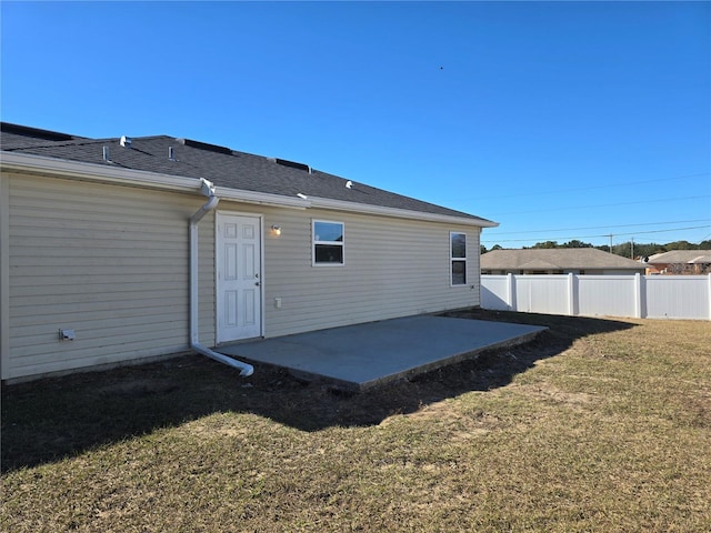 back of house with a patio area and a lawn