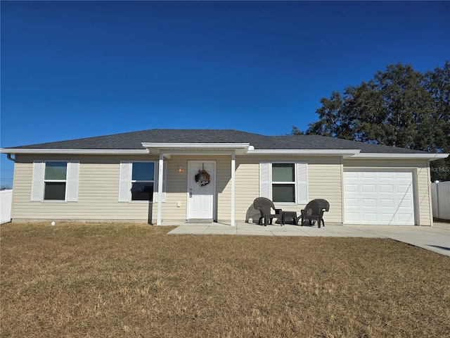 single story home featuring a garage, a front yard, and a patio area