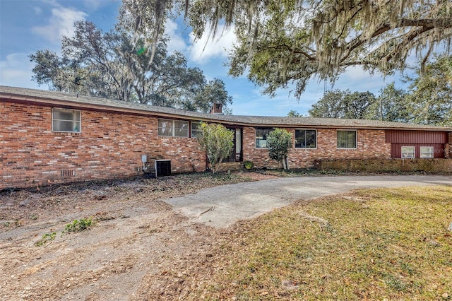 single story home featuring a front lawn and central air condition unit