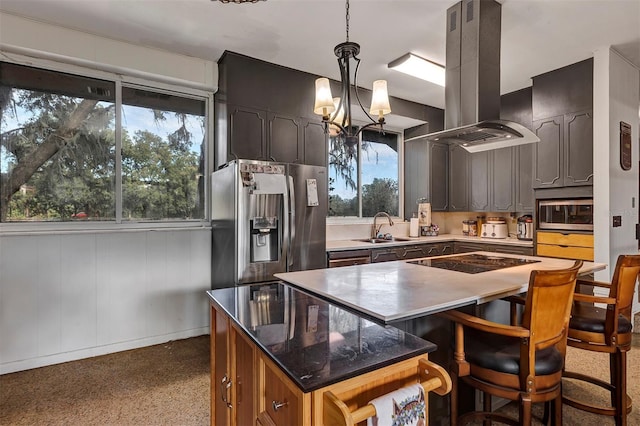 kitchen with a wealth of natural light, island range hood, a kitchen island, and appliances with stainless steel finishes