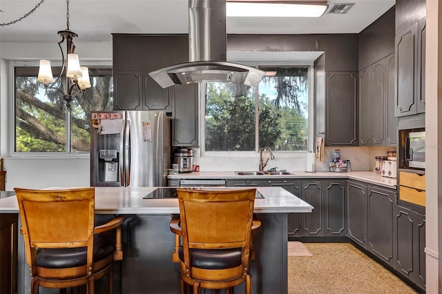 kitchen with a kitchen bar, island exhaust hood, sink, and appliances with stainless steel finishes