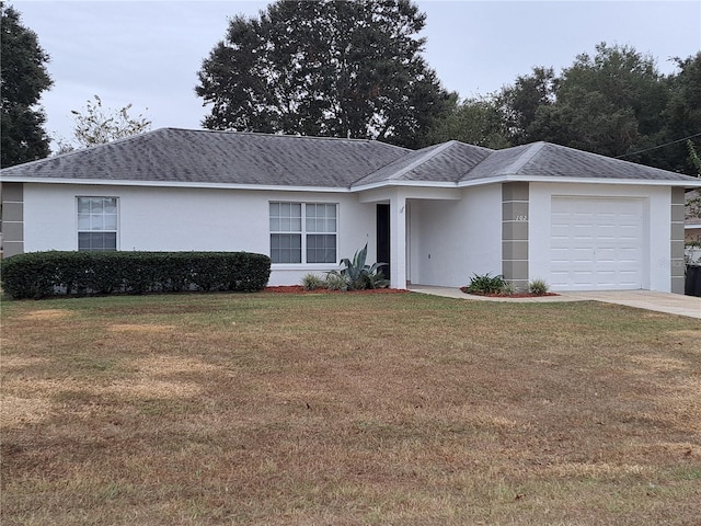 single story home with a garage and a front lawn